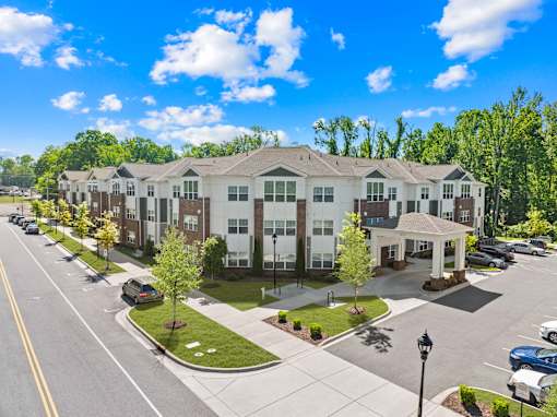 A large apartment complex with a parking lot in front.