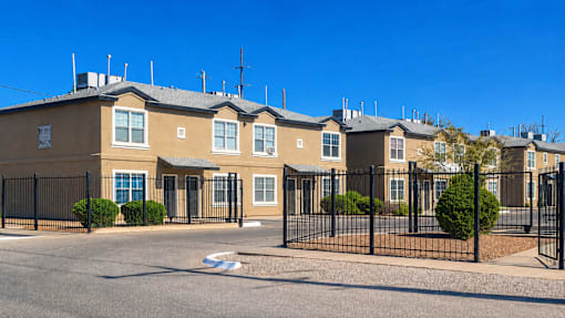 A row of houses with black fences in front.