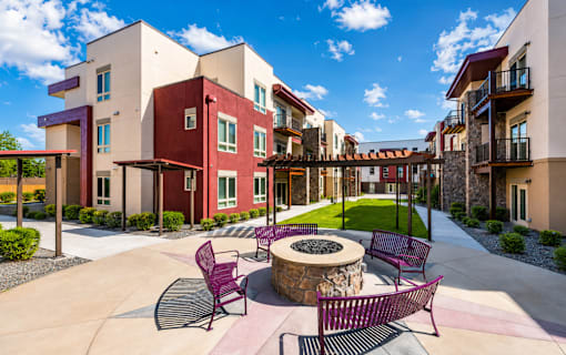 A courtyard with a fire pit and chairs.