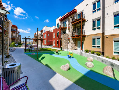 A playground with a blue and green surface and rocks.