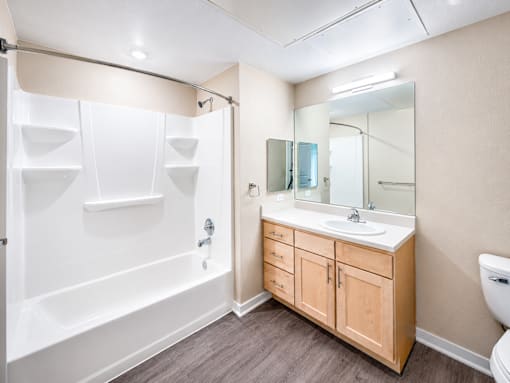 A bathroom with a white tub, sink, and toilet.