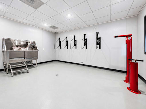 A room with a red object on the right and a metal table on the left.
