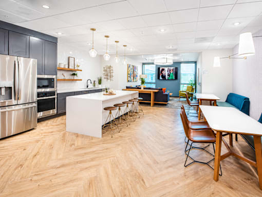 A modern kitchen with wooden floors and a dining table with chairs.