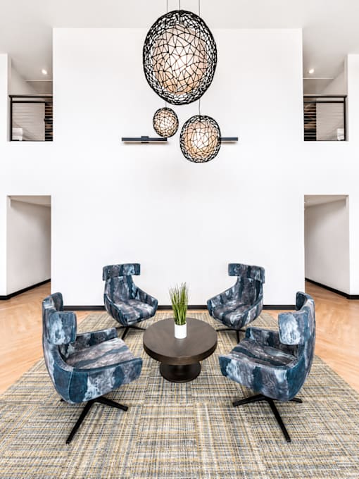 A living room with a white wall and a set of blue chairs.