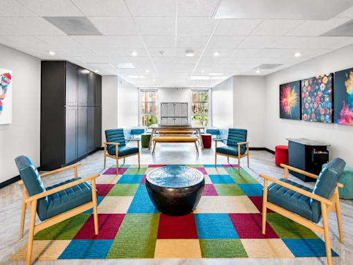 A room with a colorful rug and wooden furniture.