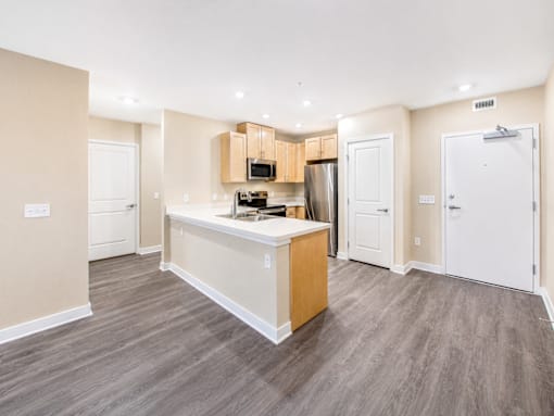 A kitchen with a white counter and a microwave on top.