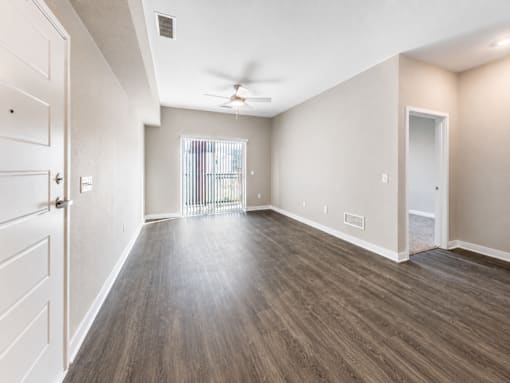 A room with a ceiling fan and light, and a door leading to a balcony.