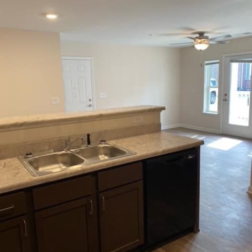 A kitchen with brown cabinets and a marble countertop.