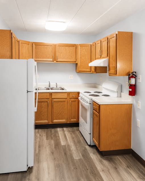A kitchen with wooden cabinets and a white refrigerator.