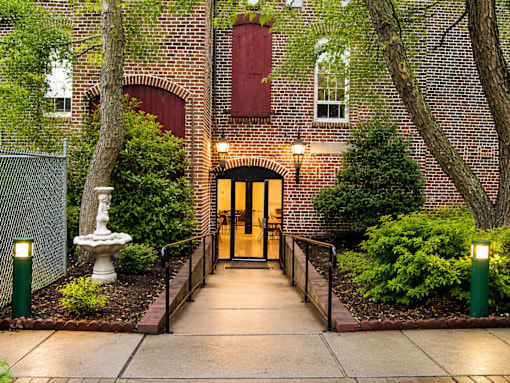 A brick building with a red window and a wooden door.