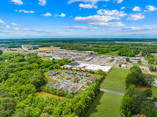 A bird's eye view of a residential area with houses and a parking lot.