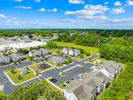 A bird's eye view of a residential area with houses and a parking lot.
