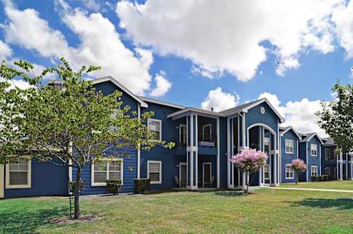 A blue building with a tree in front of it.