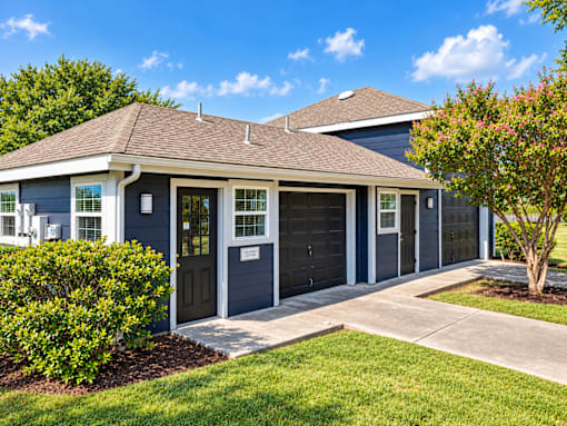 A two-car garage with a grey exterior and a brown roof.