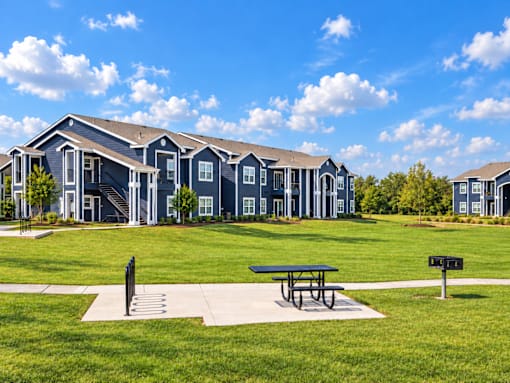A large blue building with a picnic table in front of it.