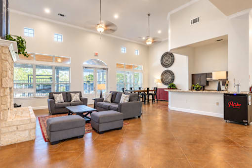 A living room with a fireplace and a kitchen area in the background.