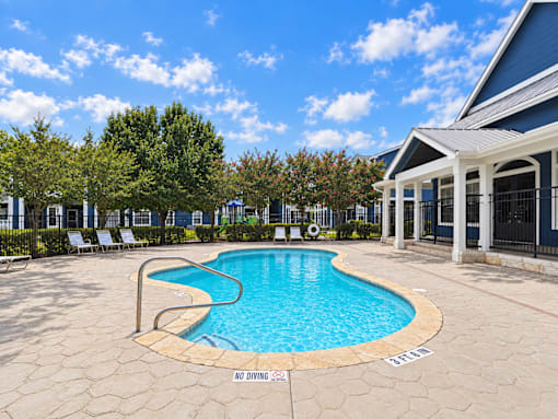 A pool surrounded by a stone patio with a sign that says "No Diving - Splash".