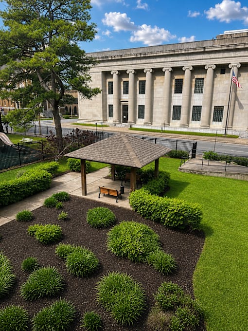 A large building with columns and an American flag on top.