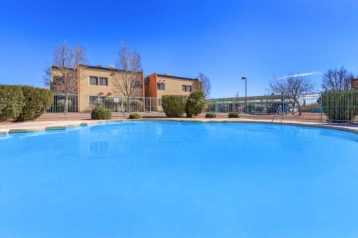 a large swimming pool with a building in the background