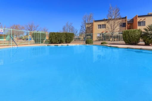 a large swimming pool with a building in the background
