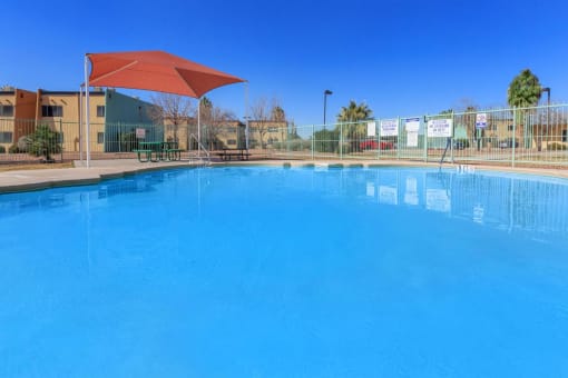 a large swimming pool with an umbrella in front of a building