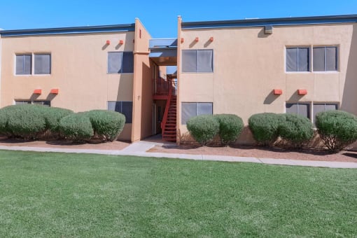 an apartment building with a lawn in front of it