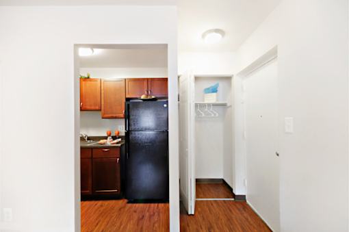 A black refrigerator in a kitchen with wooden cabinets.