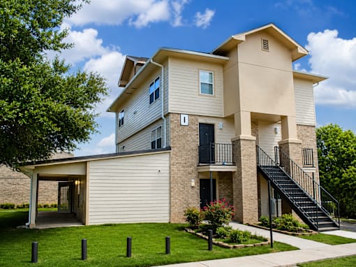 A two-story house with a balcony and a staircase leading to the second floor.