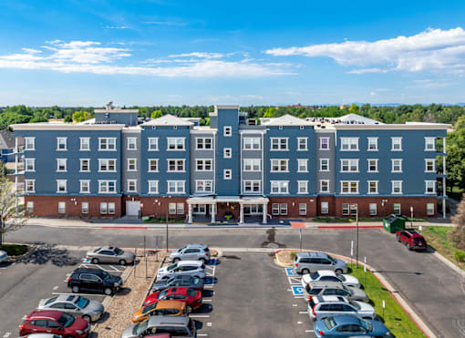 A large building with a parking lot in front of it.