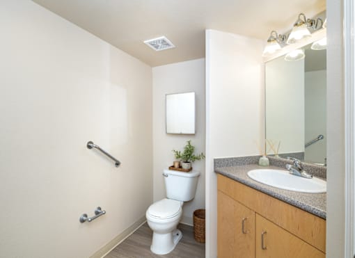 A white toilet sits in a bathroom next to a sink.