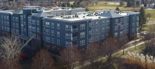 an aerial view of a blue building with a white roof