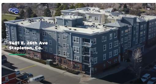 an aerial view of an apartment building with a parking lot