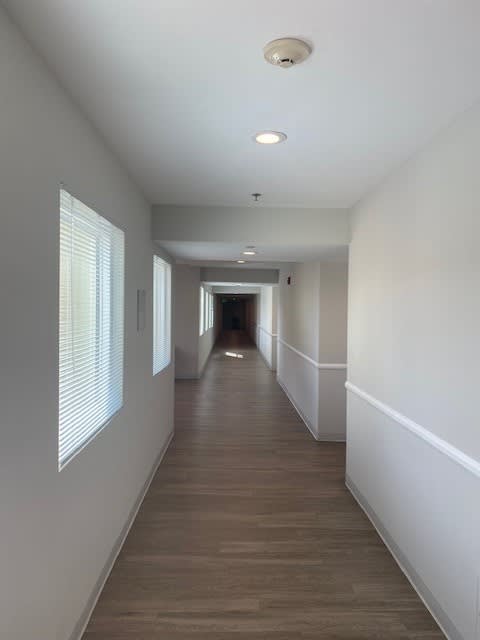 a long hallway with white walls and a wood floor