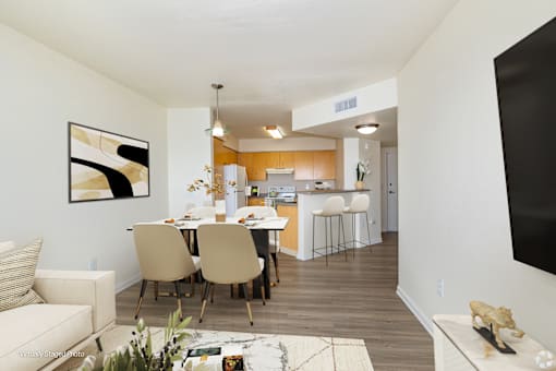 A modern living room with a dining area in the background.