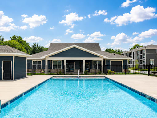 A swimming pool in front of a house.