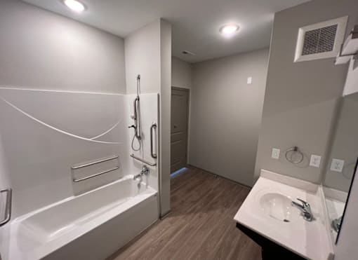 A bathroom with a white tub and sink.