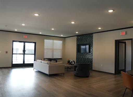 A living room with a white couch and a television on the wall.