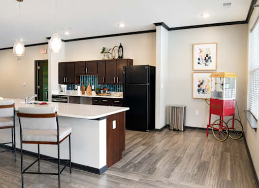 A kitchen with a black refrigerator and a white countertop.
