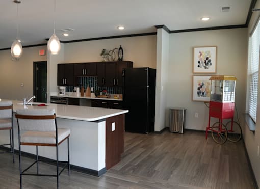 A kitchen with a white counter and a black fridge.