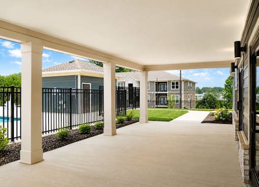 A covered walkway leads to a pool and houses.