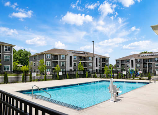 A swimming pool in front of apartment buildings.