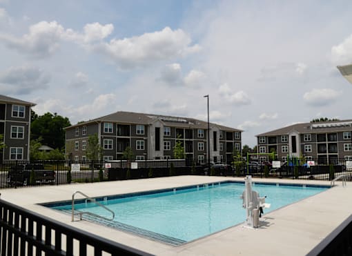 A swimming pool in front of apartment buildings.