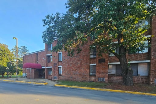 a large brick building with a tree in front of it