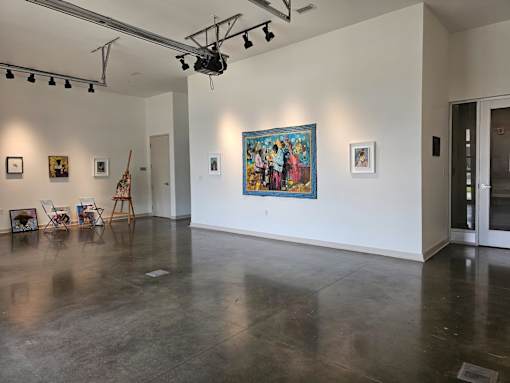 A room with a grey floor and a painting on the wall.