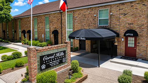 A brick building with a sign that says "Coral Hills Apartment".