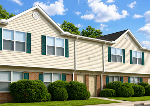 A row of houses with green shutters and a number 118 on the front.