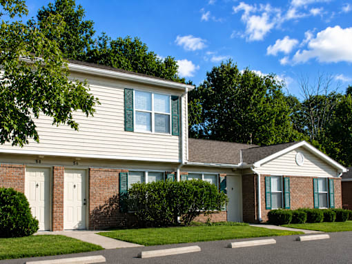 A house with a white door and green shutters.