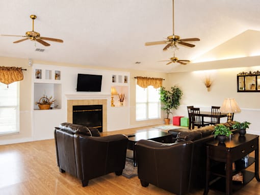 A living room with a fireplace, two chairs, and a coffee table.