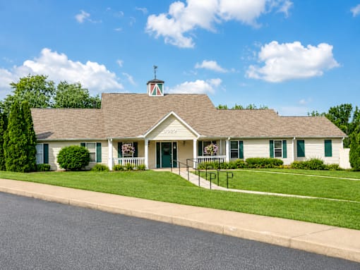 A house with a green lawn and a blue sky.