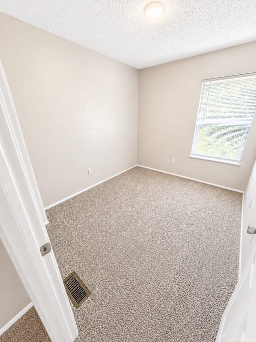 A room with a carpet floor and a window.